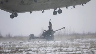 Soldiers difficulty attach an M119A3 Howitzer to a CH47 Chinook Helicopter middle of a snowstorm [upl. by Leahci]