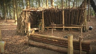 Camping in a Debris Shelter Bushcraft  Lanterns Log Bench Deer Hide Beds [upl. by Atekram476]